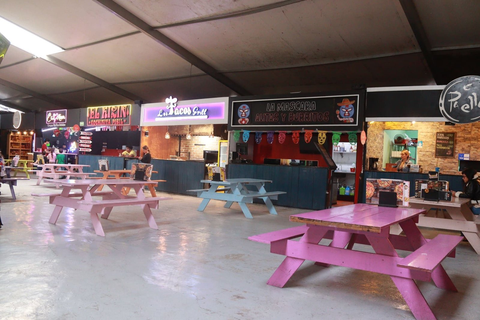 Pasillo del corredor gastronómico con los letreros de El Kizin, Los Tacos Grill, La Máscara y Paella